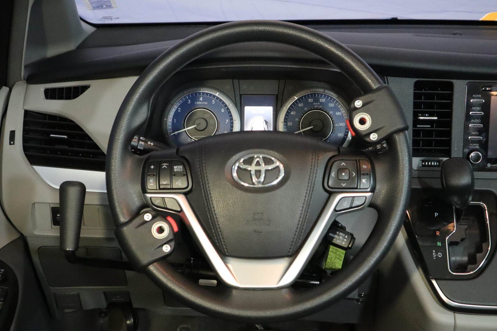 A spinner knob clamped to a steering wheel for one-handed steering.